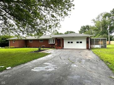 Charming brick ranch home featuring an attached two car garage and mature trees at 6237 E Lynn Dr, Mooresville, IN 46158