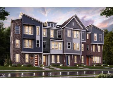 View of the new construction townhomes featuring brick and siding exteriors, colorful doors, and manicured lawns at 7339 Bayview Run, McCordsville, IN 46055