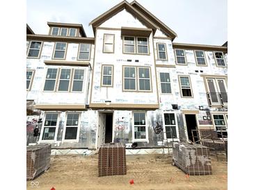 New construction home with lots of windows and currently under construction with brick pallets in front at 7347 Bayview Run, McCordsville, IN 46055