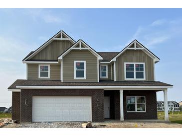 Two-story home showcasing a brick and siding exterior with a two-car garage and a welcoming front porch at 764 Parker Ln, Westfield, IN 46074