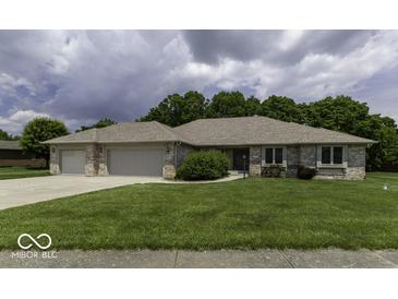Charming single-story brick home featuring a well-maintained lawn and an attached two-car garage at 7741 Long Branch Dr, Indianapolis, IN 46259