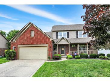 Charming two-story home features a brick facade, covered porch, well-maintained lawn and an attached two car garage at 8030 Parcrest Ct, Indianapolis, IN 46259