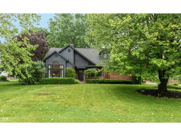 Charming exterior view of a well-maintained home with beautiful landscaping and mature trees at 8140 Springwater W Dr, Indianapolis, IN 46256