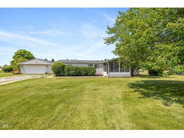 Exterior view of home with well-maintained lawn, detached garage, and screened-in porch at 1114 E 234Th St, Sheridan, IN 46069
