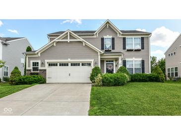 Charming two-story home featuring manicured lawn, flower boxes, attached two-car garage, and tasteful, neutral vinyl siding at 1217 Old Vines Trl, Greenwood, IN 46143