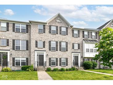 Charming brick townhome featuring manicured lawn, symmetrical design and inviting front entrances at 174 Straughn Ln, Westfield, IN 46074
