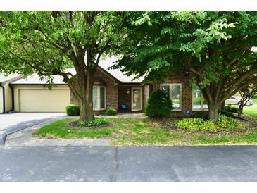 Charming brick home featuring mature trees, a two-car garage, and a well-maintained front yard at 1783 Cloister Dr, Indianapolis, IN 46260