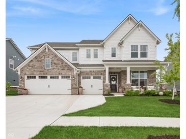 Beautiful two-story home featuring brick and white siding, a three-car garage, and a well-manicured front lawn at 19652 Shadow Trace Path, Westfield, IN 46074