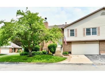 Charming brick and vinyl townhome featuring a well-manicured lawn and attached garage at 2442 N Willow Way, Indianapolis, IN 46268