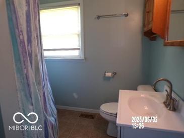 Standard bathroom featuring a single sink, toilet, and bathtub with patterned shower curtain at 26 Crescent Ct, Chesterfield, IN 46017
