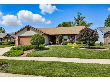 Charming single-story home featuring a manicured lawn and beautiful landscaping at 3916 St Simons Ct, Indianapolis, IN 46237
