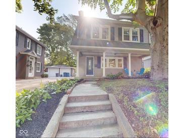 Charming two-story home featuring a welcoming front porch and landscaped garden leading to the front door at 4619 N Park Ave, Indianapolis, IN 46205