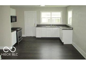 The bright kitchen features white cabinets, dark countertops, and stainless steel appliances at 620 S 2Nd St, Noblesville, IN 46060