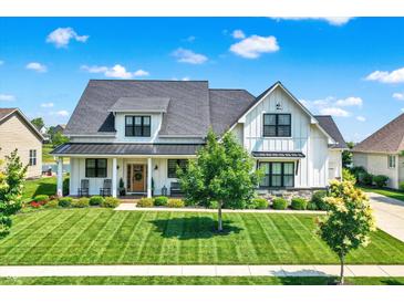Beautiful two-story modern farmhouse featuring a manicured lawn and inviting front porch at 6882 Bladstone Rd, Noblesville, IN 46062