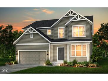 Charming two-story home featuring a two-car garage, manicured lawn, and classic architectural details at sunset at 7177 Firestone Rd, Whitestown, IN 46052