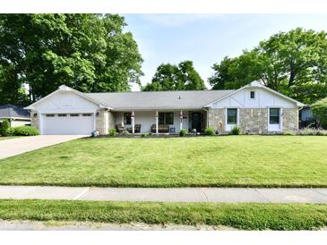 Charming single story home featuring stone accents, well-manicured lawn, and attached two car garage at 7242 Highburry Dr, Indianapolis, IN 46256