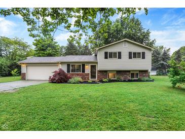 Charming split-level home with a well-maintained lawn and mature trees creating a welcoming curb appeal at 7504 Troon Ct, Indianapolis, IN 46237