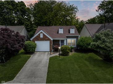 Charming home with a well-manicured lawn, brick accents, and an attached garage at 9700 River Oak E Ln, Fishers, IN 46038