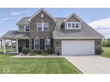 Charming two-story brick home featuring a well-manicured lawn and attached two car garage at 1215 W Curry Rd, Greenwood, IN 46143