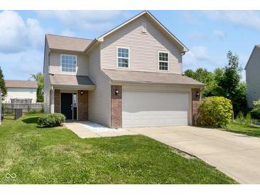 Two-story home featuring vinyl siding, a brick facade, an attached two car garage and a well-maintained front lawn at 1525 Bluestem Dr, Greenwood, IN 46143
