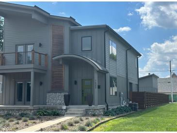 Modern two-story home featuring neutral siding, stone accents, manicured landscaping, and an inviting arched entryway at 1622 Cornell Ave, Indianapolis, IN 46202