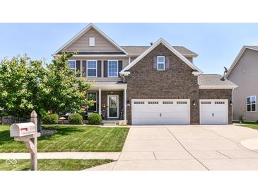 Charming two-story home with a manicured lawn, brick accents, and a three car attached garage at 7733 Chestnut Eagle Ct, Zionsville, IN 46077