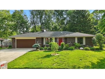 Charming brick home with a well-manicured lawn, a brown garage door, and a striking red front door at 8635 Bishops Ln, Indianapolis, IN 46217