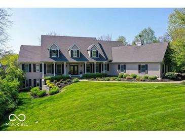 Stately home with manicured lawn, black shutters and columns, and mature trees under a clear sky at 10707 Club Chase, Fishers, IN 46037