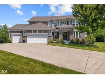 Charming two-story home boasts a three-car garage, a brick facade, and a beautifully landscaped front yard at 15047 Glenmoor Cir, Carmel, IN 46033