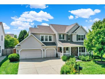 Charming two-story home with a well-maintained lawn, two-car garage, and inviting front porch at 16138 Palmyra Green, Westfield, IN 46074