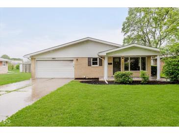 Charming single-story home with a well-manicured lawn and attached garage at 2925 E 8Th St, Anderson, IN 46012