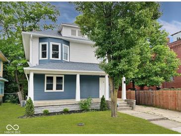 Charming two-story home with blue and white siding, a covered front porch, and well-maintained landscaping at 3011 N New Jersey St, Indianapolis, IN 46205