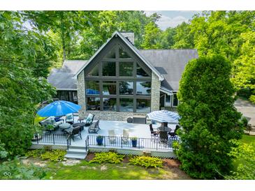Stunning lake house featuring a large deck, floor to ceiling windows, and well-maintained landscaping at 3695 Windsor Pl, Martinsville, IN 46151