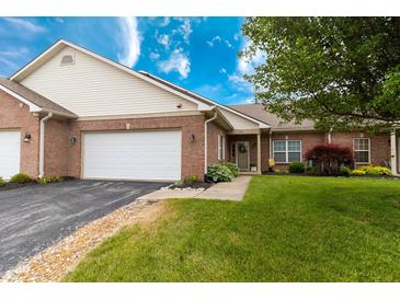 Charming brick home featuring an attached two car garage, a well-manicured lawn, and beautiful landscaping at 4291 Washington Blvd, Plainfield, IN 46168