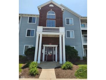 Charming condo building with red brick facade, blue siding and well maintained landscaping at 5011 Amber Creek Pl # 205, Indianapolis, IN 46237