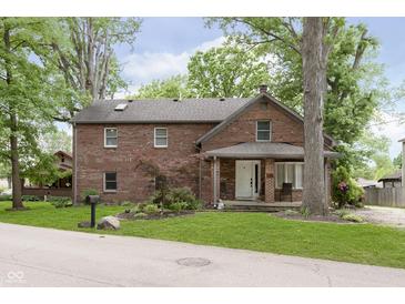 Charming two-story brick home with a cozy front porch and mature trees, offering classic curb appeal at 5110 S State Ave, Indianapolis, IN 46227