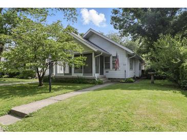 Charming home with a well-maintained lawn and cozy screened front porch perfect for enjoying the outdoors at 6125 Winthrop Ave, Indianapolis, IN 46220