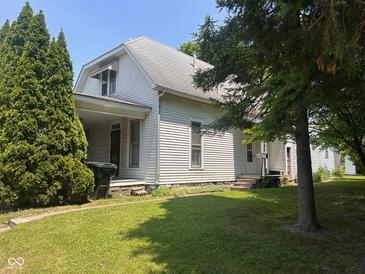 Traditional two-story home with covered porch and mature trees on a well-maintained lawn at 712 Cottage Ave, Anderson, IN 46012