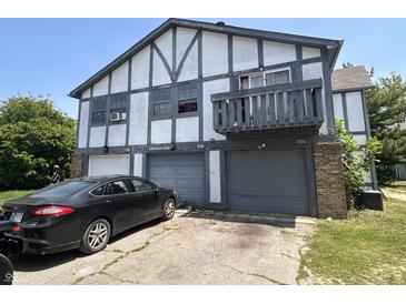 Two-story townhouse with a garage and dark trim detailing on a sunny day at 9794 Kingscross Ct, Indianapolis, IN 46235