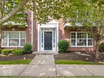 Charming red brick home featuring a black front door with white trim and manicured landscaping at 11509 Reagan Dr, Fishers, IN 46038