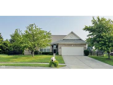 Charming brick home featuring a well-manicured lawn, mature trees, and a two-car garage at 1176 Everton Ct, Greenwood, IN 46143