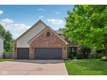 Charming brick home featuring an attached two-car garage and a well-manicured front lawn at 13938 Charleswood Ct, Fishers, IN 46038
