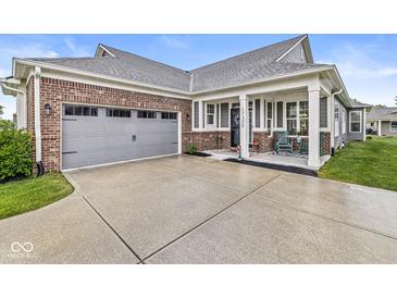 Charming home featuring a brick facade, gray siding, covered front porch, and attached two-car garage at 17309 Graley Pl, Westfield, IN 46074