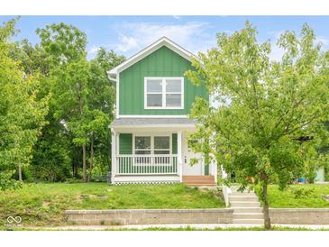Charming two-story home featuring a green exterior, white trim, and a welcoming front porch at 2427 N Rural St, Indianapolis, IN 46218