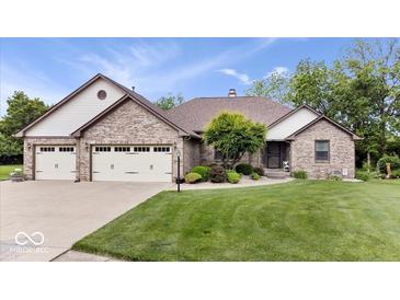 Charming brick home with a well-manicured lawn, attached garage, and inviting landscaping at 2818 Locust Dr, Indianapolis, IN 46227
