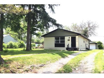 Charming single-story home with light yellow brick, a small garage, and a well-maintained front yard at 3026 Stuart St, Indianapolis, IN 46218