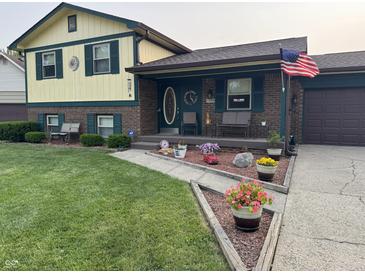 Charming two-story home with brick and siding exterior, landscaped yard, and inviting front porch decor at 4928 Dancer Dr, Indianapolis, IN 46237