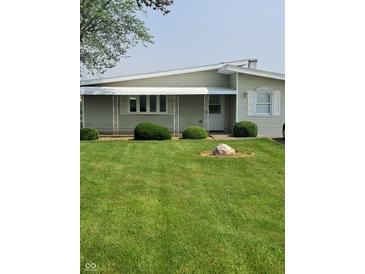 Charming single-story home featuring a well-maintained lawn and awning-covered entry at 520 E County Road 500 S, Muncie, IN 47302
