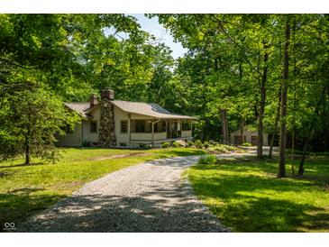 Charming home featuring stone accents, covered porch, and long driveway at 8717 Moore Rd, Indianapolis, IN 46278