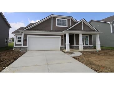 Charming single-Gathering home featuring brown siding, stone accents, and a spacious two-car garage at 10132 Redwood Peak Ln, Indianapolis, IN 46259